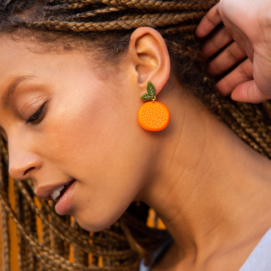 medium orange earrings on model