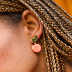 small peach earrings on model