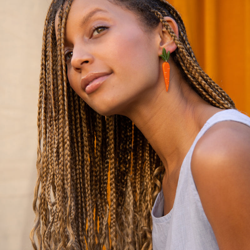 small carrot earrings on model with braids