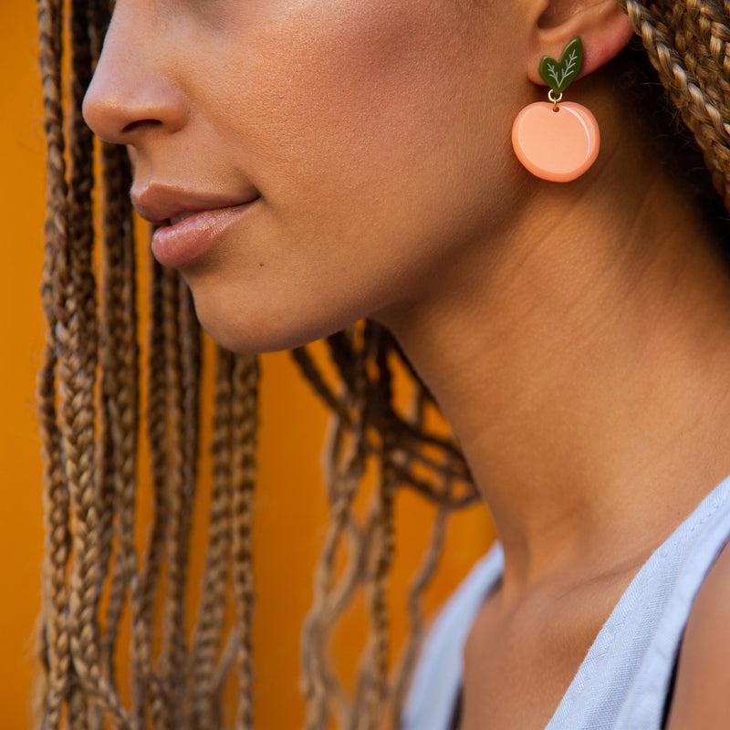 medium peach earrings on model
